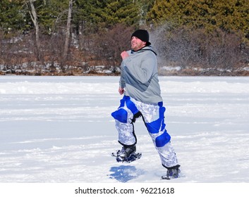 Man Running Across Frozen Lake In Winter Snowshoe Race