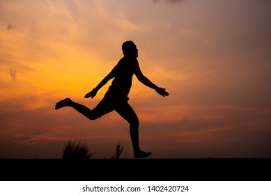 Man Running Alone At Beautiful Sunset In The Road At Park . Summer Sport And Freedom Concept. Athlete Training On Dusk. - Image