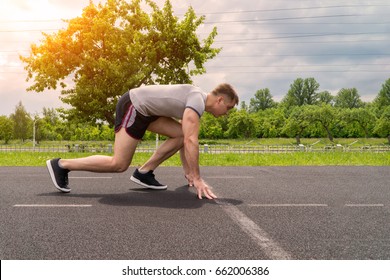 The Man Is Running Around The Stadium. Training Outdoors. Side View.