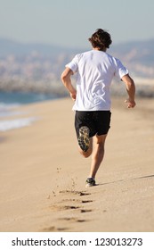 Man Running In The Beach With His Footprints Back