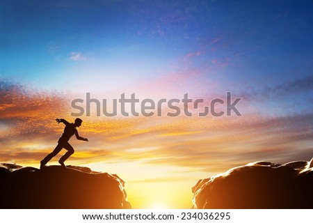 Man running fast to jump over precipice between two mountains. Concepts of determination, business, challenge, success, risk etc.