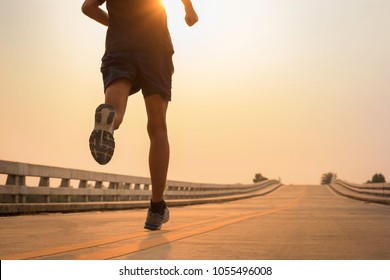 Man running jogging on bridge road. Health activities, Exercise by runner. - Shutterstock ID 1055496008