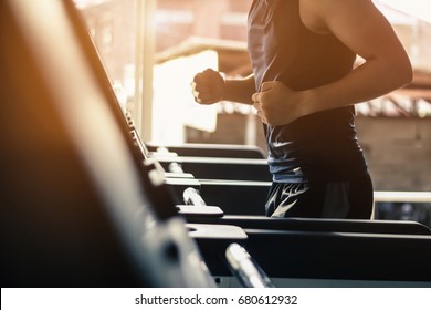 Man running in a modern gym on a treadmill concept for exercising, fitness and healthy lifestyl.lowkeylight.vintage tone.selective focus.