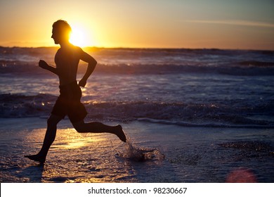 Man running on the beach at sunset - Powered by Shutterstock