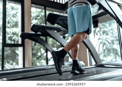 A man running on track treadmill, exercise fitness. Fitness, gym, workout and lifestyle concept. - Powered by Shutterstock