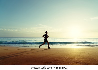 Man Running On Tropical Beach At Sunset