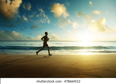 Man Running On Tropical Beach At Sunset