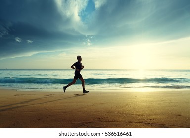 Man Running On Tropical Beach At Sunset