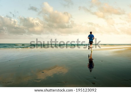 Man running on tropical beach at sunset. Maspalomas. Gran Canaria.