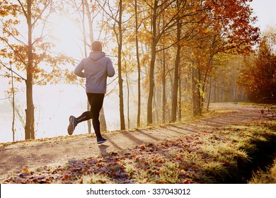 Man running in park at autumn morning. Healthy lifestyle concept - Shutterstock ID 337043012