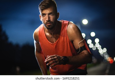 Man running through the city street at night. - Powered by Shutterstock