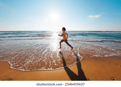 man runs barefoot along the beach by the sea. Powerful runner, sprint and summer training. A young male runner runs along an empty beach at dawn. run near the sea. - Powered by Shutterstock