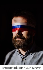 Man With Russian Flag Blindfold On Black Background, Russian Propaganda Closed People's Eyes Concept.