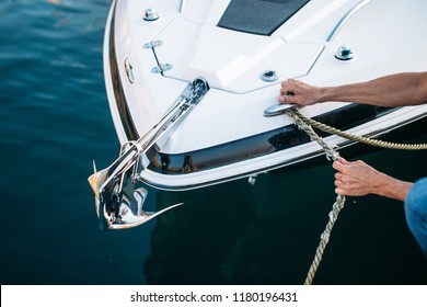 Man s hand with boat rope. Yachtsman moors his motor boat at jetty. Close up hands and bow of the boat. - Powered by Shutterstock