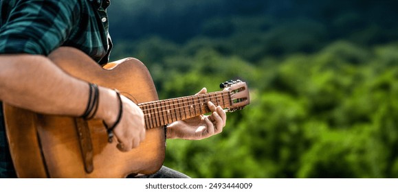 Man 's hand playing acoustic guitar, song. Nature background. Guitars acoustic. Male musician playing guitar, music instrument. Man's hands playing acoustic guitar. Copy space. - Powered by Shutterstock