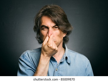 Man 's Nose Clamping Hands Of A Bad Smell.