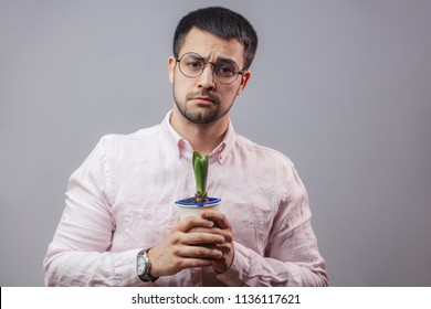 Man Is Sad Because His Flower Has Stopped To Grow.close Up Photo. Isolated Grey Background