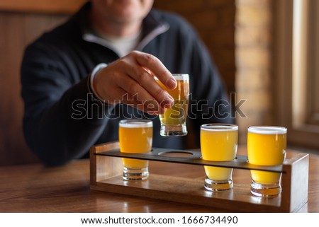 Man sampling beer from a flight