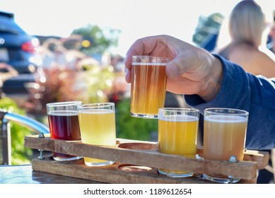 Man Sampling A Variety Of Seasonal Craft Beer At An Outdoor Beer Garden, Hands Only