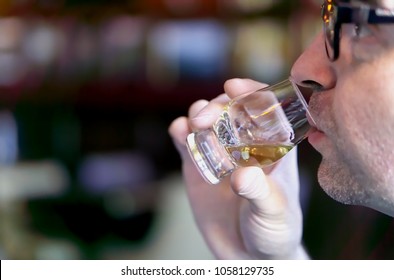 Man Sampling Whisky From A Whisky Tasting Glass, Close-up.
