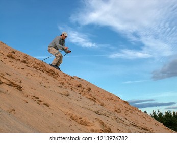 Man Sand Skiing Down Dunes In Desert. Sand-skiing Is Sport And Form Of Skiing In Which Skier Rides Down Sand Dune On Skis, Using Ski Poles. Tver, Russia - August 2006