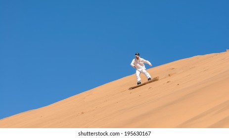 Man Sandboarding In Namibia, Africa