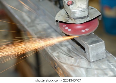 A Man Sanding A Metal Girder