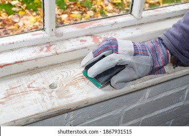 Man Sanding Wood Or Timber Sash Window, DIY At Home, UK