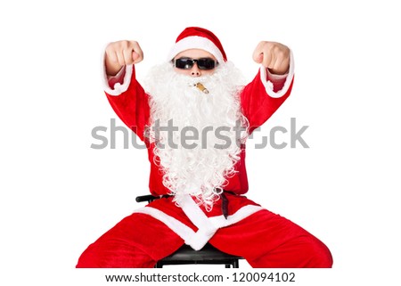 Man in Santa Claus clothes sitting in a chair wearing sunglasses with cigar shows fig isolated on white background