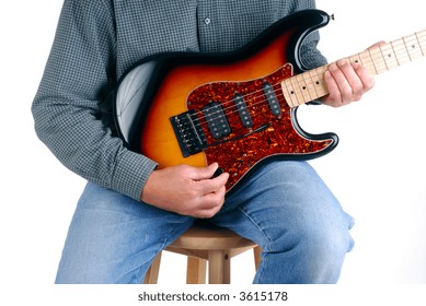 Man Sat On A Stool Playing A Six String Electric Guitar, Isolated Over White