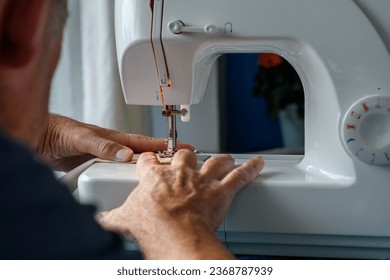 Man sat at a sewing machine. Over the shoulder perspective, landscape view. copy space.  - Powered by Shutterstock