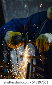 Man Sawing Metal With A Rotary Angle Grinder On Work Table And Generating Sparks