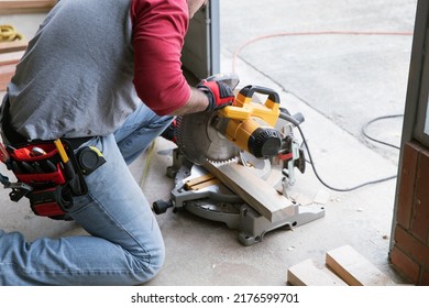 A man sawing wood with a multi material construction saw on the ground 