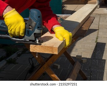 A Man Saws A Board With An Electric Jigsaw Close-up .hand Electric Saw ,the Concept Of Working With Wood