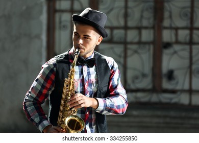 Man With Saxophone Outside Near The Brick Wall