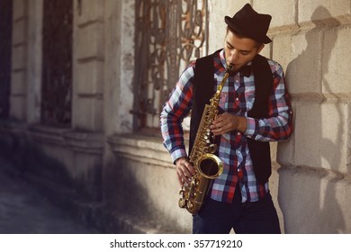 Man With Saxophone Outside Near The Brick Wall