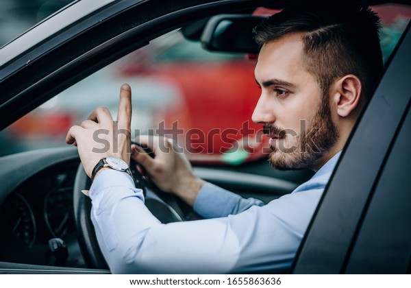 Man saying hello\
from a car while driving