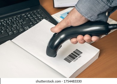 Man With Scanner Scans Barcode In A Book