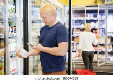 Man Scanning Bar Code On Product Through Mobile Phone