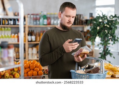 Man scans a qr code on a meat package with his mobile phone. customer uses an online payment app at a store.