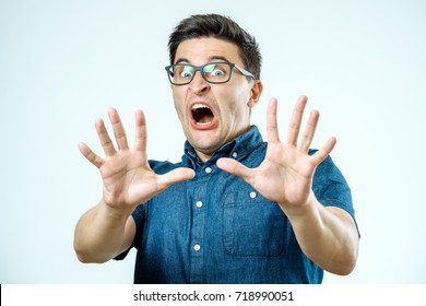 Man with scared expression on his face making frightened gesture with his palms as if trying to defend himself from someone