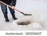 man scoops chunks of ice out of the hole