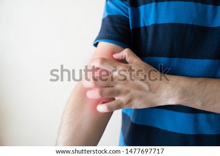 Man scratching arm from having itching  with redness rash over white background. Cause of itchy skin include dermatitis, eczema, psoriasis or fungal infection. Health care concept. Close up.