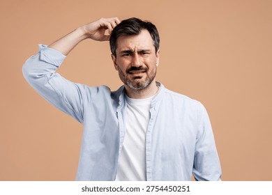 Man scratching head, looking puzzled, expressing uncertainty, doubt, or thinking deeply