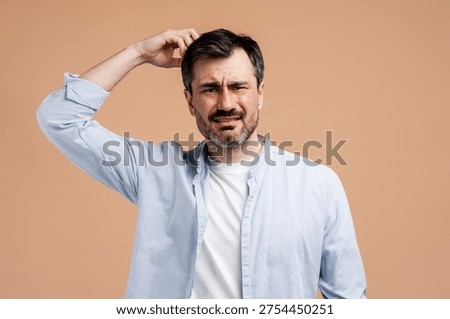 Man scratching head, looking puzzled, expressing uncertainty, doubt, or thinking deeply