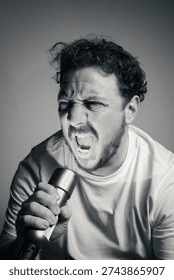 Man screaming into flashlight with intense rage expression and dramatic lighting black and white portrait
