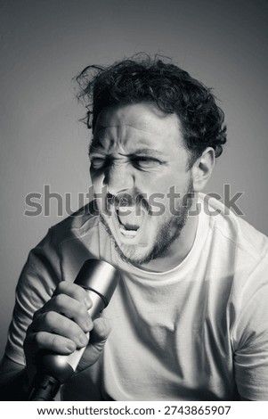 Man screaming into flashlight with intense rage expression and dramatic lighting black and white portrait
