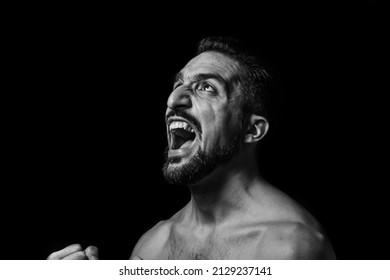 A Man Screams On A Black Background. Black And White Male Portrait. Expression Of Negative Emotions