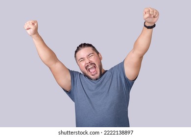 A man screams and shouts in elation. Overjoyed man celebrating victory. Isolated on a gray background. - Shutterstock ID 2222138897