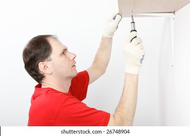 Man With Screwdriver Installing The Shelf On Angle Brackets